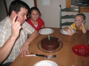 Marc pinching the flame out of the candle.  Look at Carson's eyes.